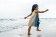 © Chanakon - Cheerful adorable little girl having fun outdoor and playing with sand with beach kid toys on the beach in the summer vacation at sunset, happy healthy toddler playful on the tropical seaside.