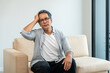 © Chanakon - Asian mature old man sitting bored serious thinking in living room at home. Portrait of serious depressed senior asian man. Mature People with problem in life