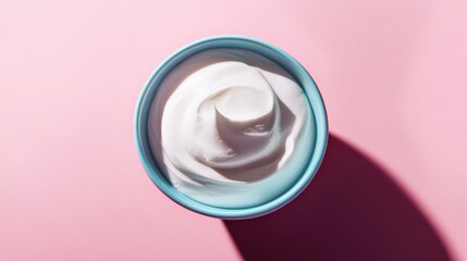 Aufkleber - Overhead shot of creamy yogurt in blue bowl on pink background showcasing smooth texture and healthy eating concept
