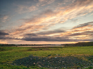 Wall Mural - Peaceful sunrise nature scene with green field and spectacular and dramatic sky. Galway city area, Ireland. Irish landscape scene. Nobody. Travel and tourism.