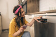 © milanmarkovic78 - Woman Using Mobile App To Control Dishwasher