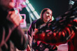 © qunica.com - A cheerful woman is seen enjoying the colorful lights and lively atmosphere at a night-time outdoor fair, reflecting joy and connection.
