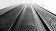 © THUA - Modern skyscraper facade in black and white bottom view sharp steel frame glass windows white sky copy space minimalist urban aesthetic.