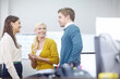 © peopleimages.com - Happy, business people and talking in office for discussion, conversation and listening on startup project. Creative agency, women and man with happiness for teamwork, planning and laugh together
