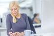 © peopleimages.com - Business woman, phone text and desk in office with social media break and scroll on website. Mobile, employee and public relations worker with internet, search and message online with technology