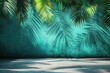 © sofia - Teal wall with tropical palm leaves casting shadows on a concrete floor