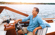 © BuyoutReese09/peopleimages.com - Luxury, mature man and boat on water for retirement, leisure and investment for travel. Wealth, happiness and male person on yacht for sailing, adventure and transportation on lake in summer