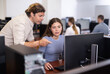 © JackF - Male teacher of computer courses helps girl student to figure out with performance of difficult task, master ark. Mentor observes students studies, looks at monitor screen.
