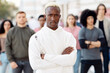 © Prostock-studio - African american man leader standing over multiracial group of protestors on the street. Confident black guy with arms crossed on chest leading international group of students, looking at camera