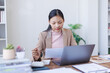 © David - Brunette young asian businesswoman sitting at the office and using laptops for work. Confident professional female wearing business financial planning casual.