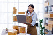 © David - Startup SME small business entrepreneur woman SME or freelance Asian woman calling phone, online marketing packaging box and delivery, SME concept