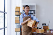 © David - Cropped of smiling woman holds a cardboard box female entrepreneurs working on receipt box and check online orders to prepare to pack the boxes, sell to customers, SME business ideas online.