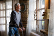 © NDABCREATIVITY - Old man with crutch feeling disappointed, lost in sad thoughts alone at home. Widow mature man.