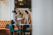 © qunica.com - Three women in business attire discussing documents in a stylish and modern office.