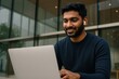 © Rawpixel.com - Man using laptop outdoors smiling
