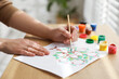 © New Africa - Woman drawing family tree at wooden table, closeup