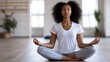 © Generative AI - Serene young woman meditating in a peaceful yoga studio, eyes closed, practicing mindfulness and inner peace.  She's sitting in a cross-legged position on a light wood floor. : Generative AI