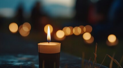 Fototapete - Single lit candle on dark stone, bokeh lights of other candles and blurred people in background, creating a peaceful, contemplative mood at dusk. : Generative AI