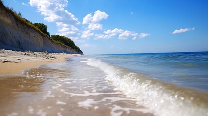 Fototapete - Serene coastal scene: gentle waves lapping a sandy beach, meeting a dramatic white cliff topped with lush green vegetation under a vibrant blue sky dotted with fluffy clouds. : Generative AI