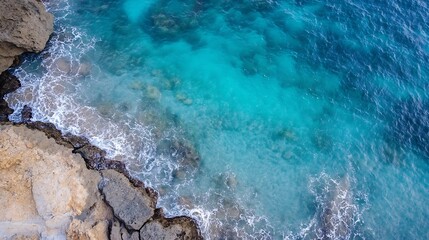 Leinwandbilder - Aerial view of turquoise ocean waves crashing against rocky coastline, showcasing a dramatic contrast between the vibrant water and the rugged, textured stone. : Generative AI