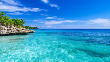 Poster - Serene turquoise ocean meets rocky shore under a vibrant blue sky, a picturesque tropical seascape ideal for travel and vacation imagery. : Generative AI