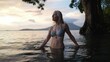 © Robert Peak - A happy, mature woman stands in the water, looking up with a smile as the sun sets behind the Concepcion volcano in Nicaraguas tranquil lake.