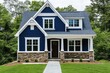 © Fauzi - Charming,  two-story,  home  with  navy  blue  exterior,  white  trim,  stone  foundation,  and  a  covered  porch.  Features  classic  architecture