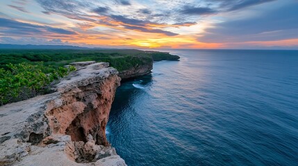 Poster - Dramatic sunset over a rugged coastline, showcasing a cliff edge overlooking a tranquil ocean.  Vibrant orange and purple hues paint the sky, while lush green vegetation lines the clif : Generative AI