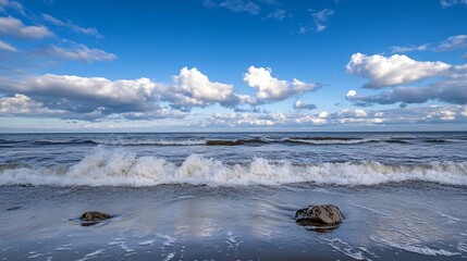 Poster - Ocean waves rolling onto a sandy beach under a partly cloudy blue sky, two rocks partially submerged in the shallow water. : Generative AI