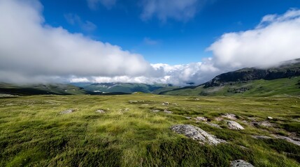 Aufkleber - Serene mountain landscape with lush green grass, scattered rocks, and fluffy white clouds drifting across a vibrant blue sky, creating a breathtaking vista. : Generative AI