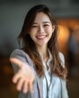 © grey - A confident Asian businesswoman extending her hand toward the camera, with palm up, showing a friendly, helpful gesture, symbolizing support and partnership