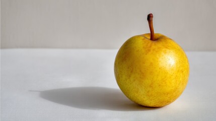 Aufkleber - A single golden pear sits on a clean white surface, showcasing its vibrant color and soft shadow, illuminated by natural light, perfect for commercial use