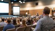 © Generative AI - Attentive audience member at a business conference, seated in a large auditorium, listening intently to a presentation on a screen. : Generative AI