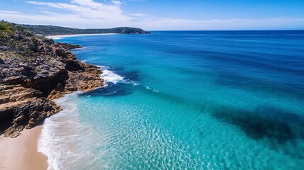 Aufkleber - Aerial view of a stunning coastline with turquoise ocean, rocky cliffs, and a sandy beach on a sunny day. The clear water reveals the ocean floor. : Generative AI