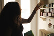 © Studio Marmellata - An Arab woman with curly dark hair reaches for a box on a shelf. She is organizing her pantry, which is full of tea and other items.