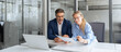 © Stock 4 You - Team of partners mature man and young woman discussing financial banking document report sitting at table in office. Two colleagues professional business people working together on project. Copy space
