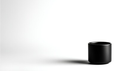 Aufkleber - Black ceramic cup positioned centrally against a seamless white background. Soft lighting enhances the matte texture, creating a minimalist aesthetic