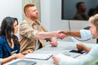 © unai - Business people shaking hands during meeting in office