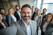 © Anna - Smiling Businessman Taking Selfie with Team at Office