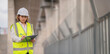 © reewungjunerr - An Asian female engineer works at a motorway bridge construction site,Civil worker inspecting work on crossing construction