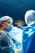© Vadim - Surgical team in OR. Surgeons work together in a sterile environment during a complex medical procedure, focusing on patient care and safety.
