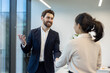 © Liubomir - A business professional is shaking hands with a colleague in a modern office setting. This portrays a collaborative work environment.