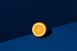 © ADDICTIVE STOCK - Half Orange on Clean Blue Surface Creates Bold Contrast