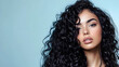 © Erika - una mujer hermosa modelo con cabello negro y ondulado rizado sobre un fondo con espacio de copia cuidado del cabello tratamientos de salon o estetica