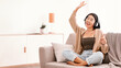 © Prostock-studio - Free Time Concept. Portrait of overjoyed asian lady wearing wireless headphones listening to her favorite song, sitting on couch in living room. Millennial lady relaxing with closed eyes and dancing