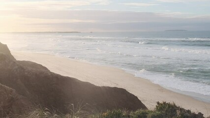 Wall Mural - golden sunlight illuminates a beautiful portuguese beach as gentle waves crash against the shore, cr