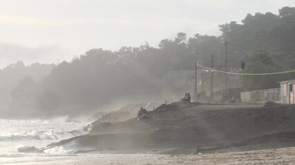 Wall Mural - golden sunbeams streaming across sandy portuguese coastline, illuminating tourists resting on small 