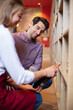 © auremar - sommelier in wine store giving recommendation for bottle of wine