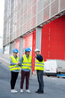 © auremar - three engineers checking plans with documents outdoors