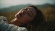 © Charoen - Extreme long shot, Korean woman lying in the grass, eyes closed, reminiscing, background is southern Italian summer countryside.